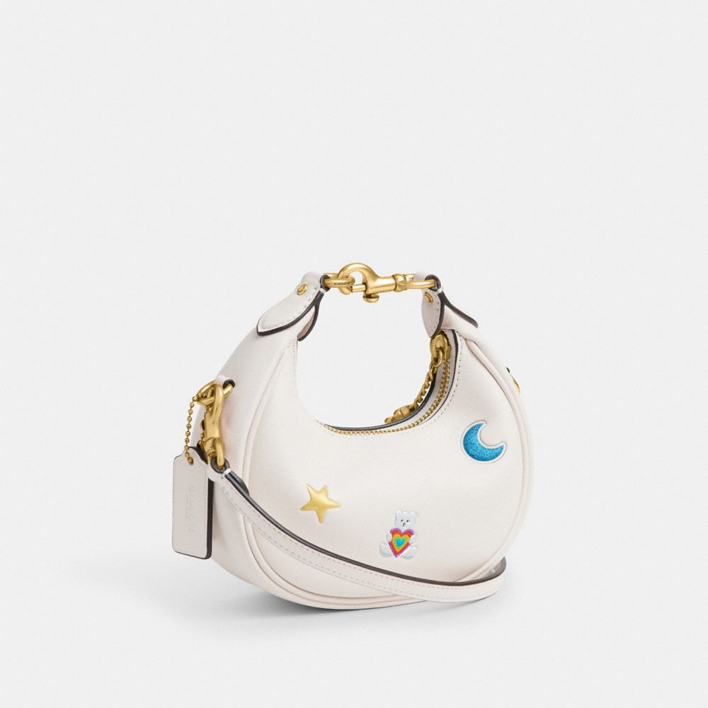 COACH®,Jonie Bag With Sticker Print,Leather,Fabric,Crossbody,Logo,Pendant,Circle,Embellished,Stitching,Piping,Pattern,Grap...,White,Angle View
