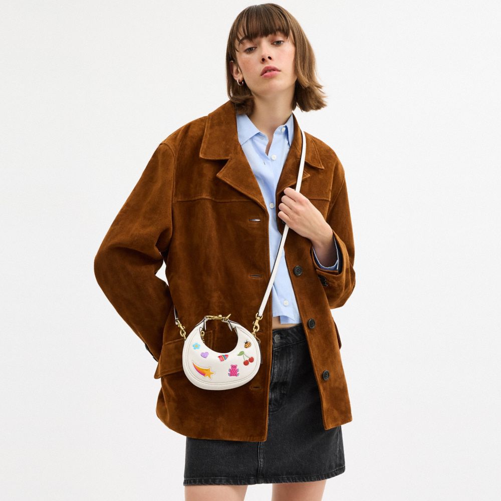 COACH®,Jonie Bag With Sticker Print,Leather,Fabric,Crossbody,Logo,Pendant,Circle,Embellished,Stitching,Piping,Pattern,Grap...,White