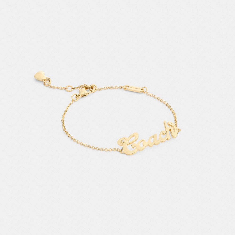 COACH®,Coach Script Nameplate Bracelet,Metal Material,Cubic Zirconia,Logo,Heart Embellishment,Gem Embellishment,Bar Embell...,Clear,Front View