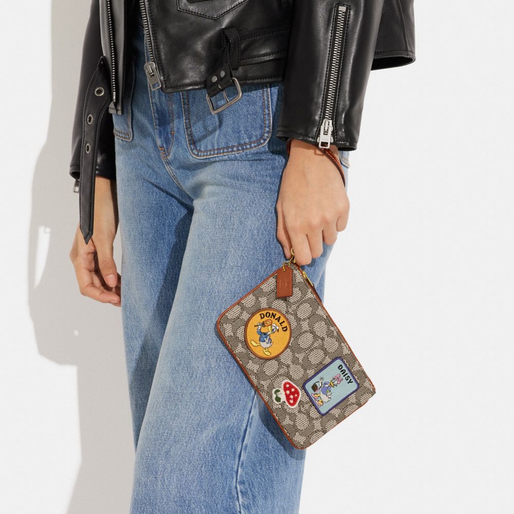 COACH®,DISNEY X COACH SMALL WRISTLET IN SIGNATURE TEXTILE JACQUARD WITH PATCHES,Signature Jacquard,Mini,,Detail View