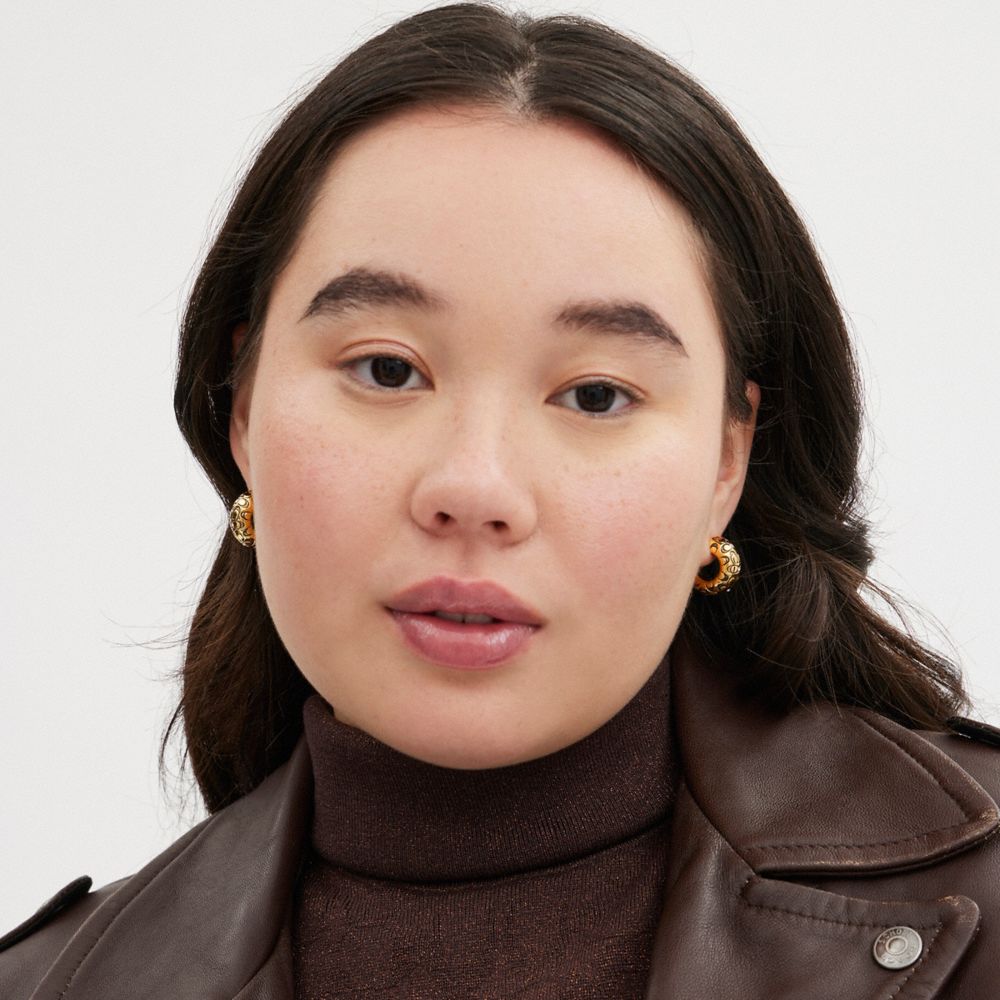 COACH®,Quilted Signature Chunky Hoop Earrings,Hoops,Crystal,Cubic Zirconia,Logo,Gem Embellishment,Yellow Gold,Titanium,Day...,Clear,Detail View